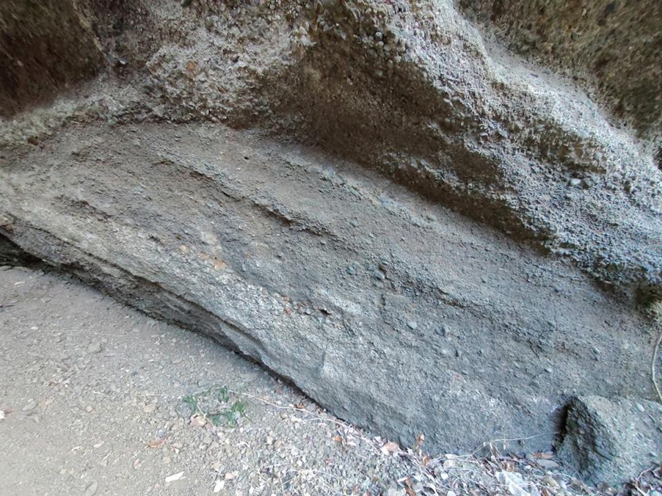 砂や小石が溜まっていった履歴（地層）がよくわかる岩肌